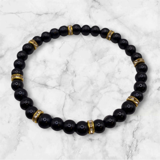 Svart pärlarmband med guld strasstenar