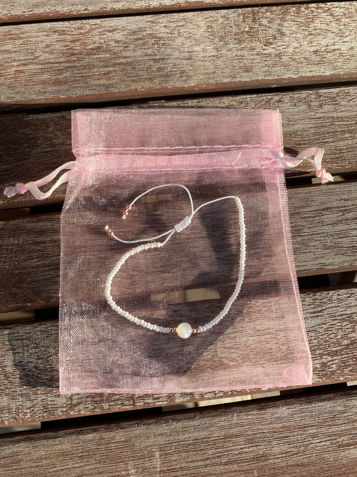 Vitt makraméarmband med en opalsten och guldpärlor