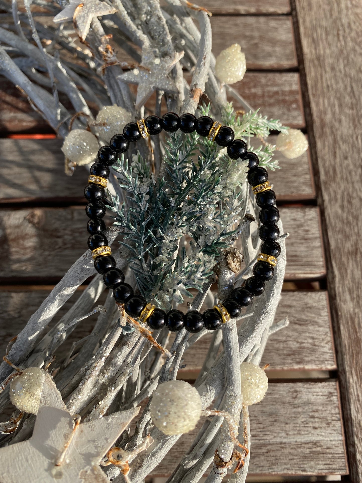 Svart pärlarmband med guld strasstenar