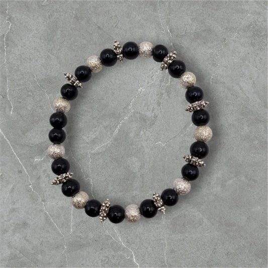 Pärlarmband med silvriga och svarta pärlor.