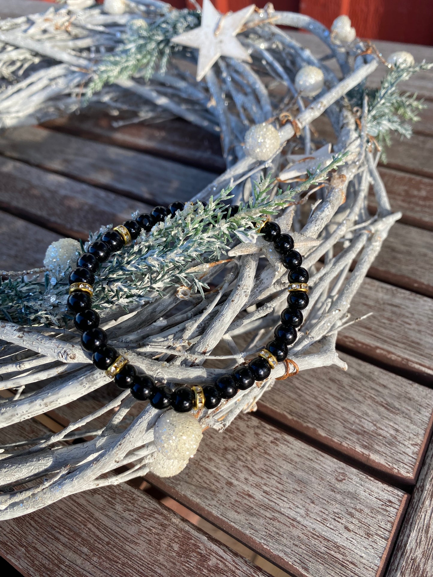 Svart pärlarmband med guld strasstenar