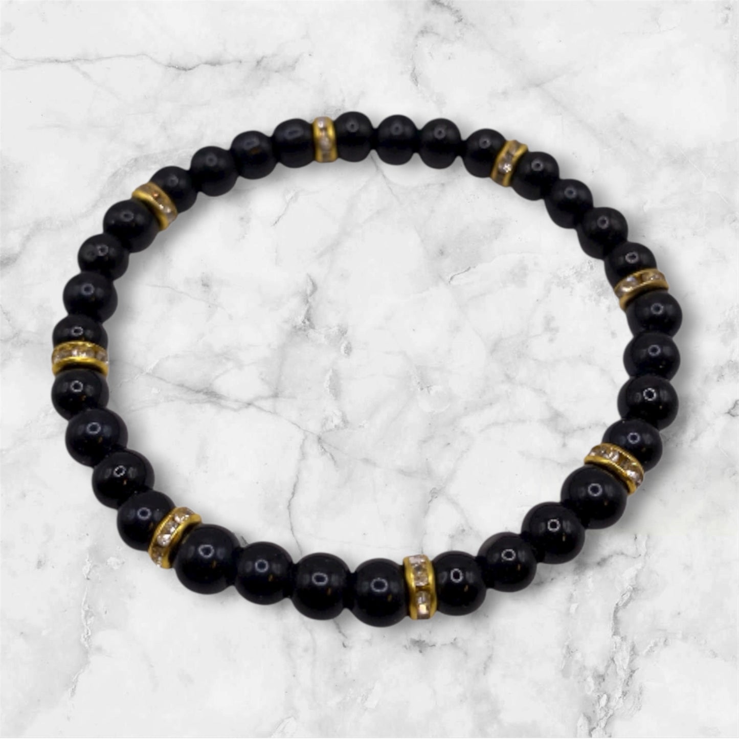 Svart pärlarmband med guld strasstenar