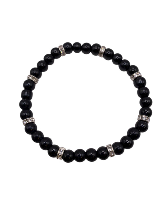 Svart pärlarmband med vita strasstenar.
