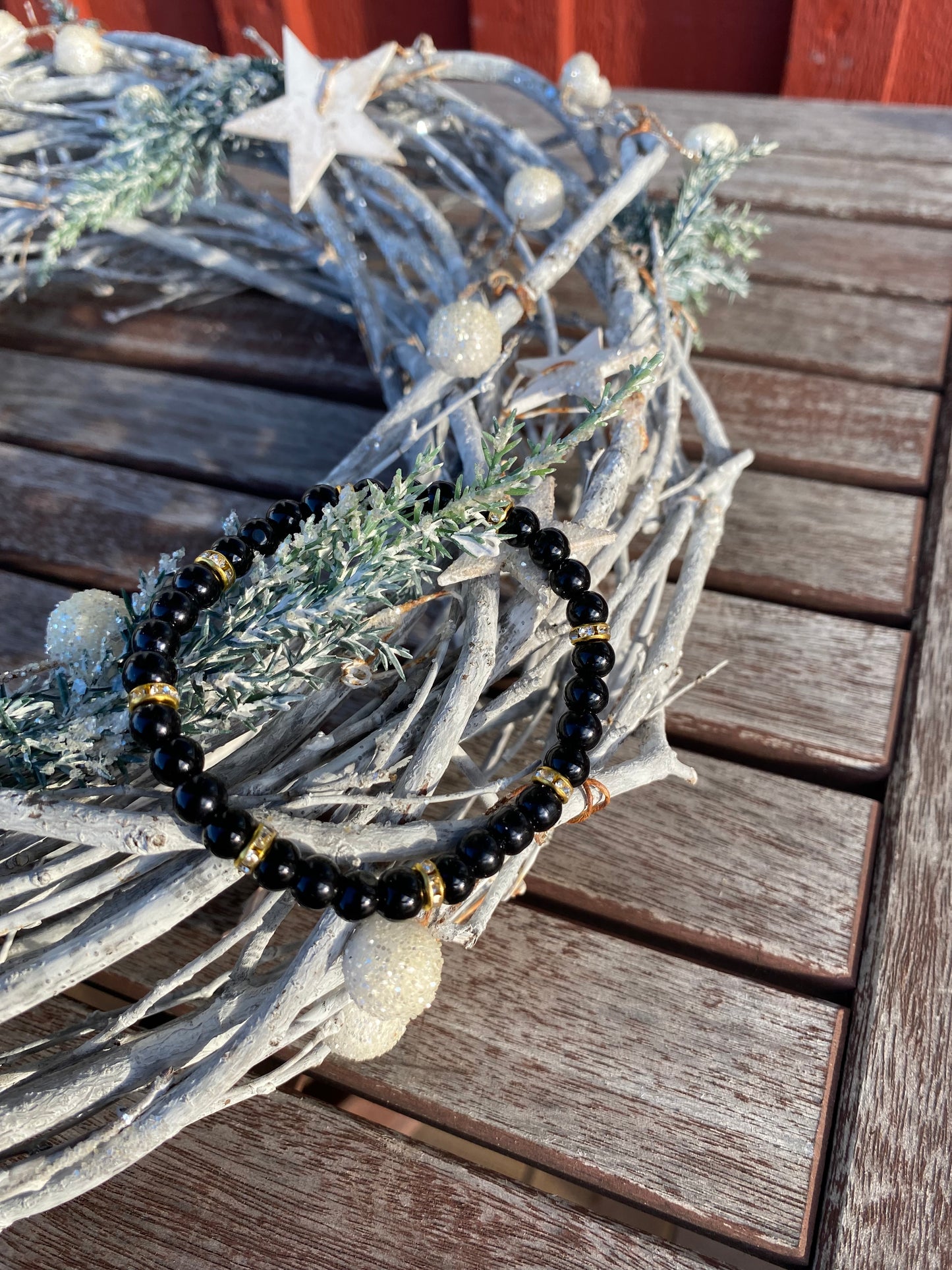 Svart pärlarmband med guld strasstenar