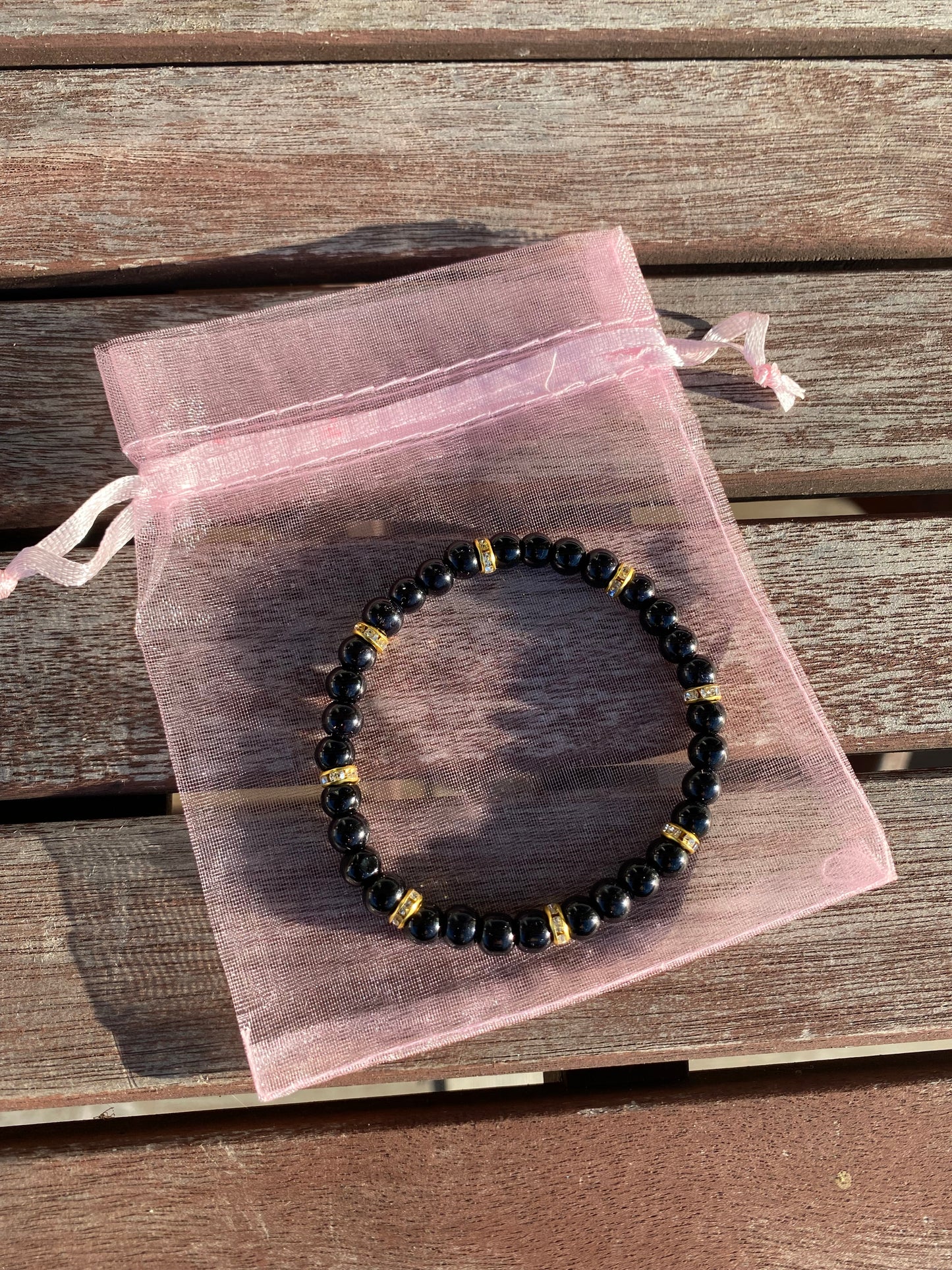 Svart pärlarmband med guld strasstenar
