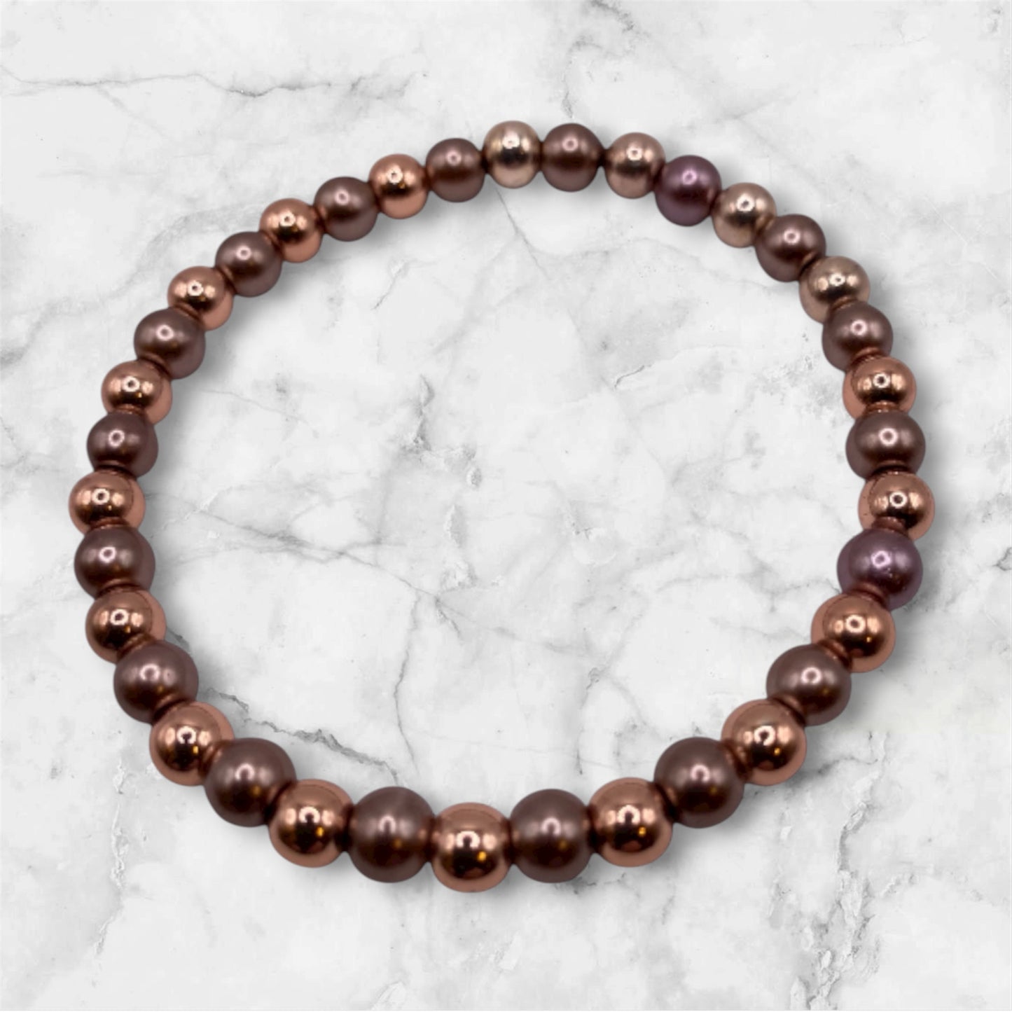 Pärlarmband med bronsfärgade och nougatfärgade pärlor.