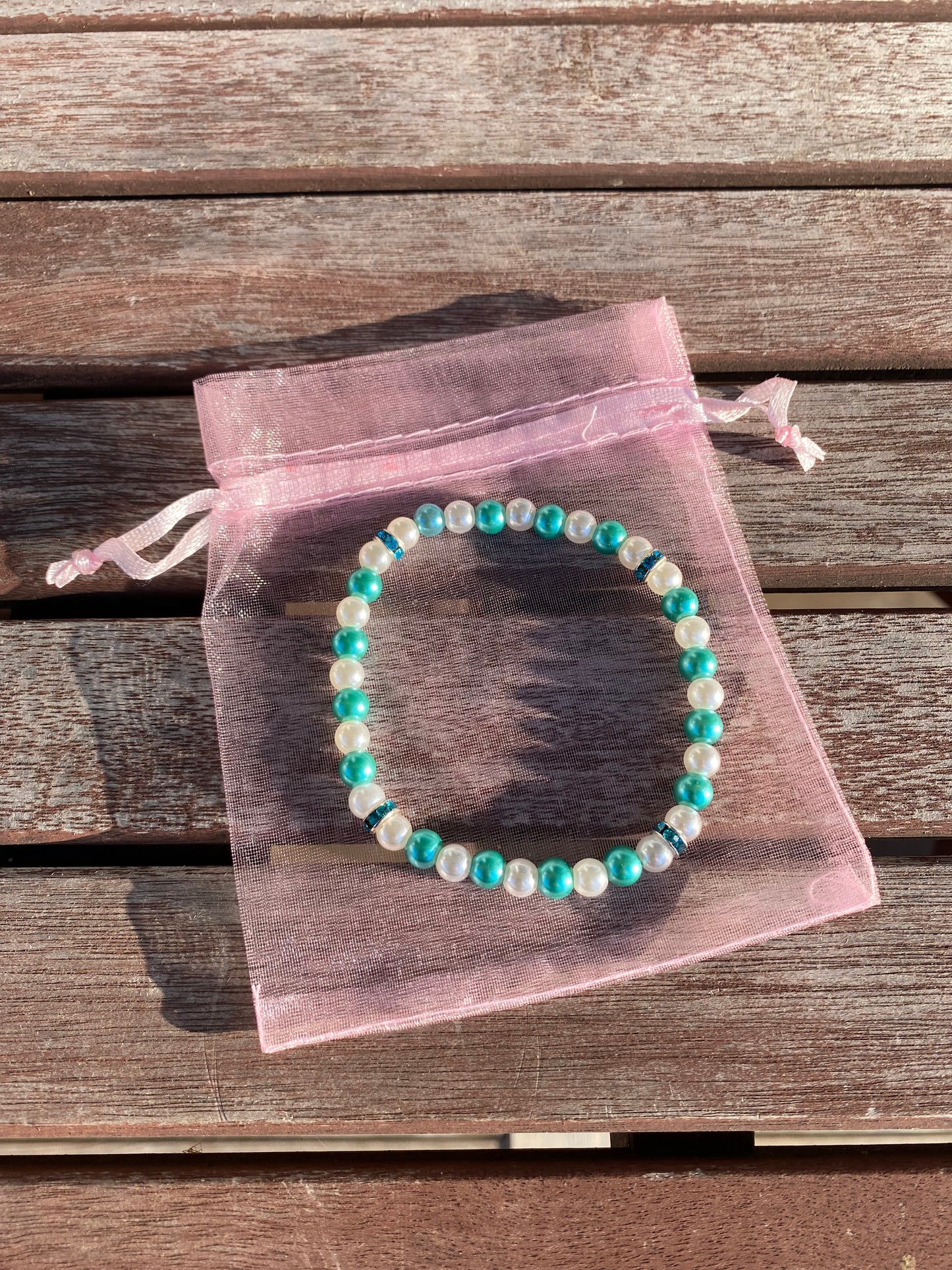 Pärlarmband med vita och turkosa vaxade glaspärlor