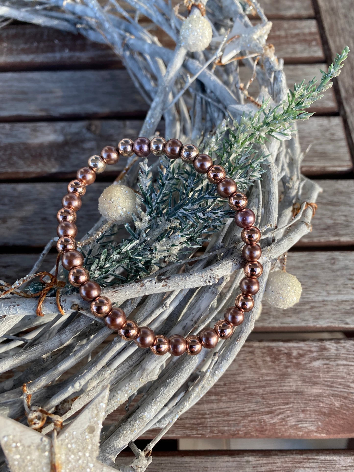 Pärlarmband med bronsfärgade och nougatfärgade pärlor.